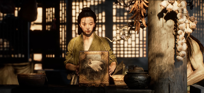 A close-up shot of someone's hands carefully holding a small, intricately decorated box. The hands are positioned centrally in the frame, showing attention and care. The box appears to be made of wood with delicate carvings and gold accents, suggesting it is valuable or significant. 