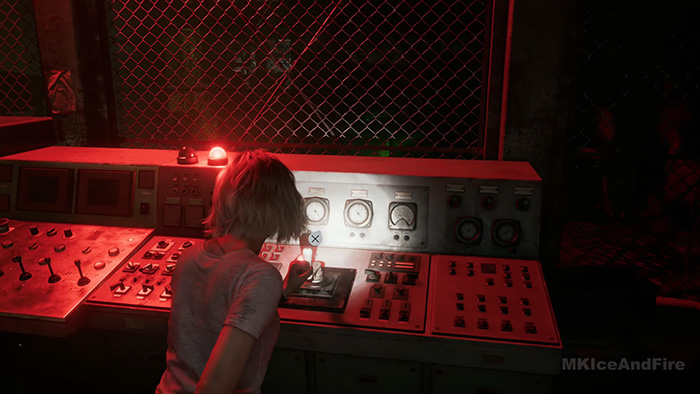 The character interacts with a secondary control panel located behind a chain-link fence in a dimly lit room.