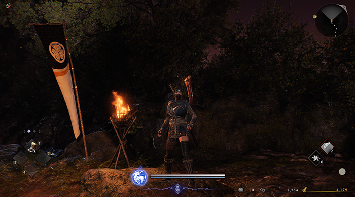 Nioh 3 character at a campsite with green Guardian Spirit icon, suggesting Ninja Style or special ability active.