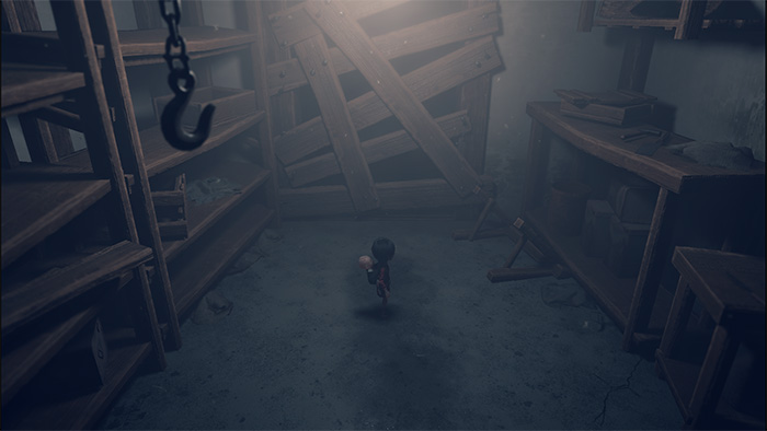 A small girl character, carrying a baby on her back, stands in a dark, cluttered storage room. The space is filled with wooden shelves, scattered tools, and debris. A single light source casts soft shadows, creating a quiet and eerie atmosphere.