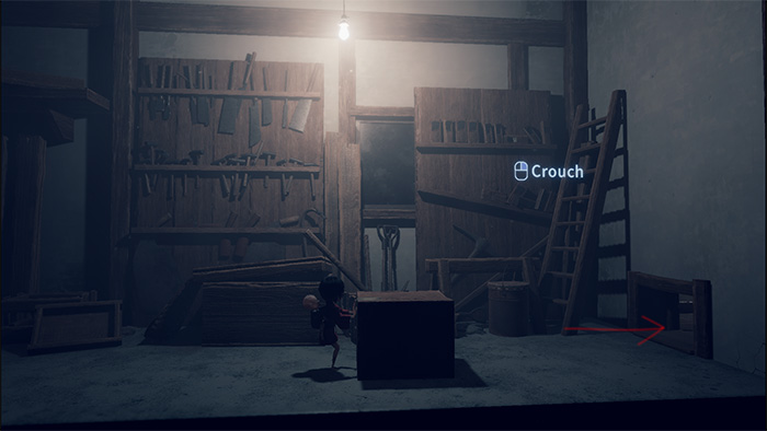 In-game view showing the player character approaching a wooden crate near a narrow opening. A UI prompt displays "Crouch" with a button icon, indicating an interactive action. A red arrow points toward the gap, suggesting a path forward. The environment is dimly lit, with tools hanging on the wall and a ladder leaning against a shelf.