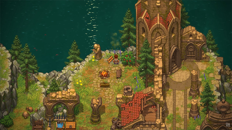 Isometric view of a coastal ruin zone in Graveyard Keeper II: a stone chapel with arched windows stands beside a cliff overlooking dark teal sea. A character sits by a campfire near ancient statues, broken brick walls, and scattered tools. Pine trees, wildflowers, and a small water basin complete the serene yet eerie atmosphere.