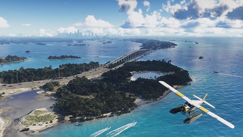 GTA6 official aerial scene: A yellow-and-white floatplane flying low over turquoise coastal waters, with lush tropical islands featuring mangrove swamps and palm forests, a multi-span highway bridge connecting landmasses, and distant city skyline under bright daytime skies.