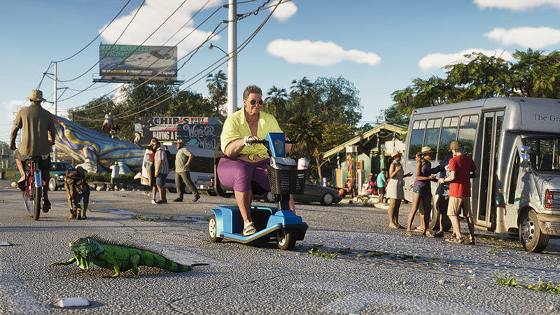 GTA6 official scene: Sunny street-level view—woman in yellow shirt and purple pants rides a blue mobility scooter; a large green iguana crosses the cracked asphalt foreground; background features a cyclist with dog, roadside vendors, graffiti-covered billboard, and a minibus with passengers boarding.