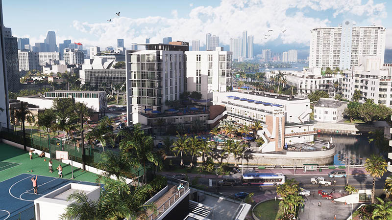 GTA6 official scene: High-angle daytime view of a vibrant coastal city district—modern high-rises and mid-rise buildings surround palm-lined streets, a basketball court with players, a bus on the road, waterfront promenade, and distant skyline with skyscrapers under partly cloudy skies.