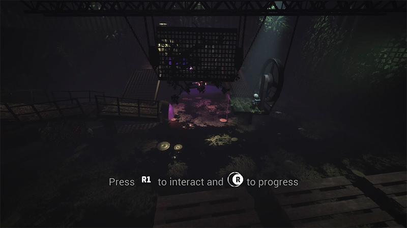 In a dim, overgrown industrial chamber, a character with light hair stands near a suspended metal cage and a large wheel. Purple ambient light glows from the floor, and wooden pallets lie in the foreground. 